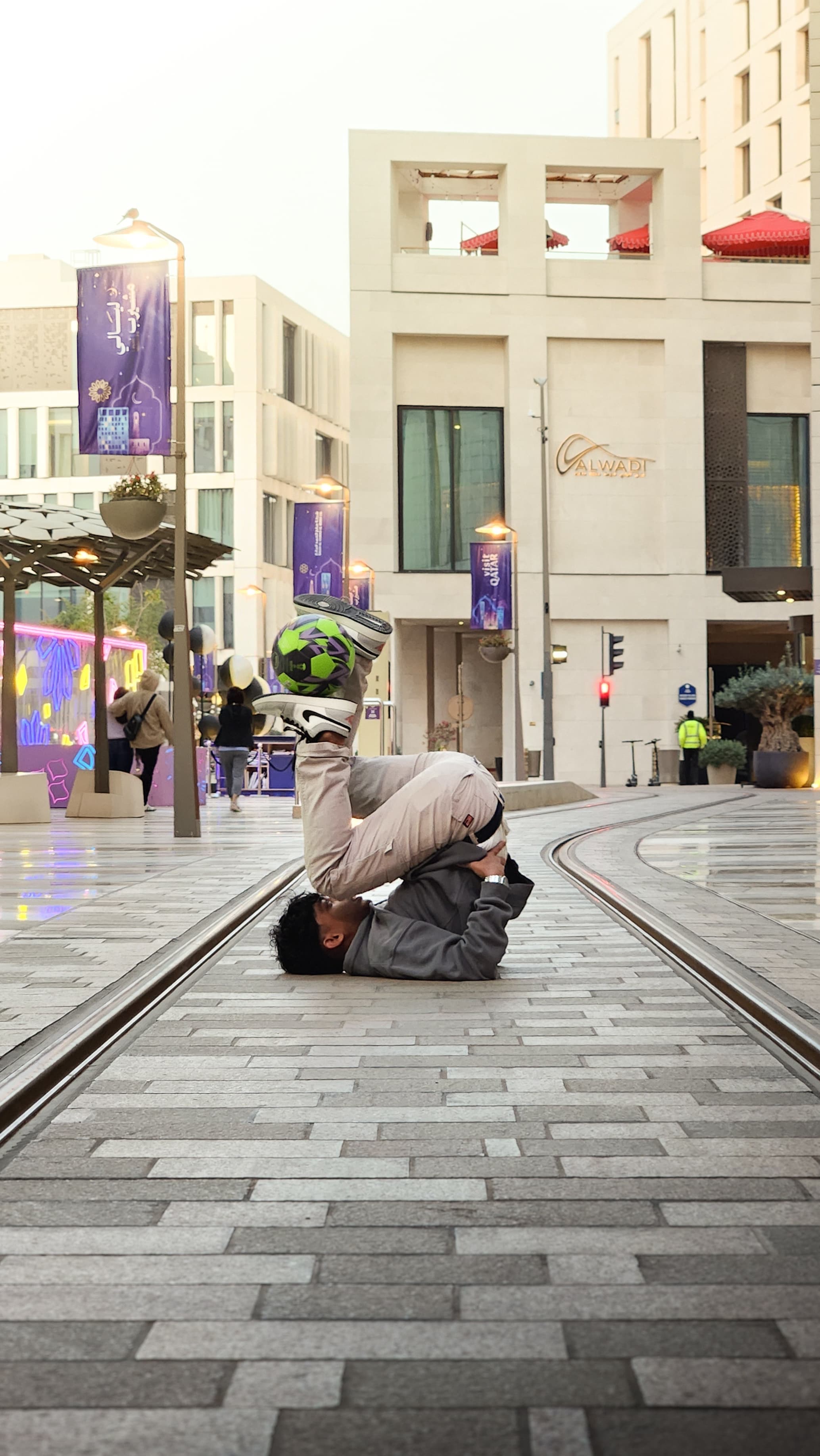 Sinan Basim performing a freestyle pose on a street in Doha, Qatar